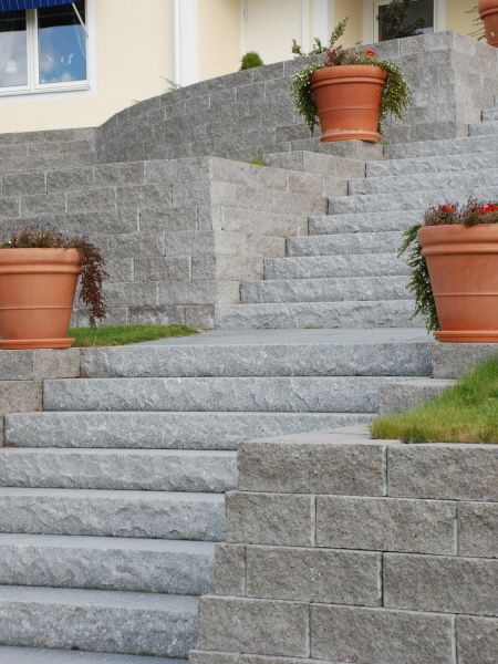 gråa stentrappor till villa entré med blomkrukor