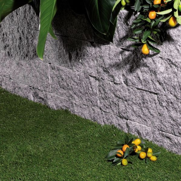 murblock i granit med gräsmatta och plantage